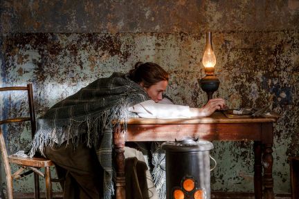 Helene liegt niedergeschlagen über einen Tisch gebeugt