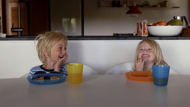 Lachende Kinder am Esstisch