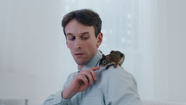 Das Eichhörnchen sitzt auf Pasis Schulter und schnuppert an Pasis Finger