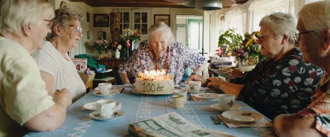 Fünf alte Frauen am Tisch mit Geburtstagskuchen (100 Jahre)