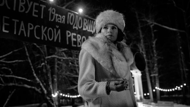 Maria in Wintermantekl vor russischem Plakat