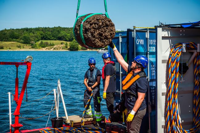 Crewmitglied streckt sich nach dem Holzstück