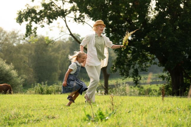 Astrid Lindgren hüpft mit ihrer Tochter über die Wiese
