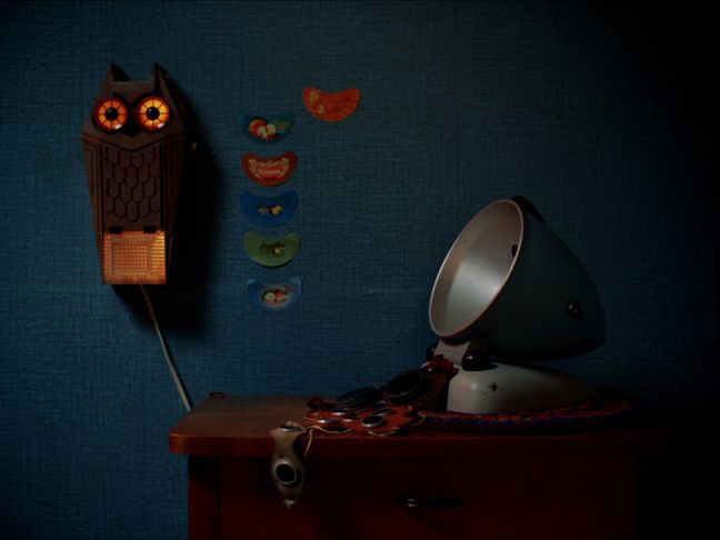 eine Eulenuhr an der Wand und verschiedene Dinge auf einer Kommode