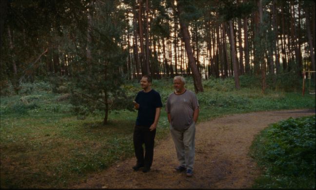 Danielius geht mit Vismantės Vater auf einem Waldweg