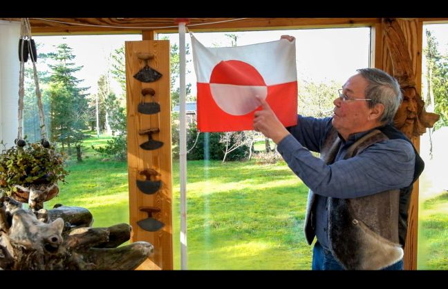 Mann zeigt auf die grönländische Flagge
