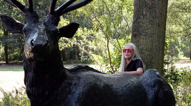 Frau mit roter Brille an Hirschstatue