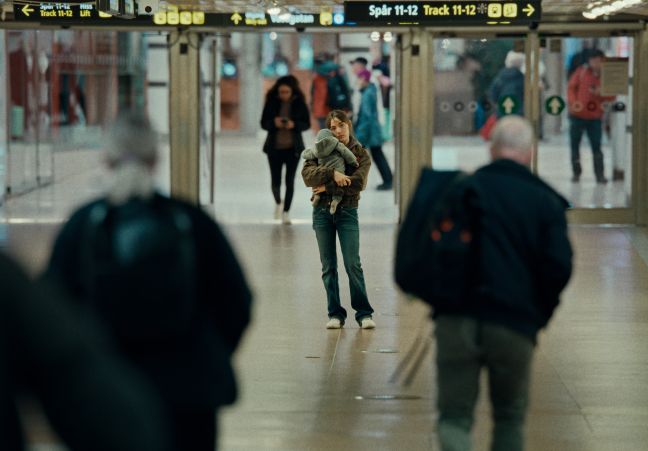 Frau mit Baby in der Bahnhofshalle