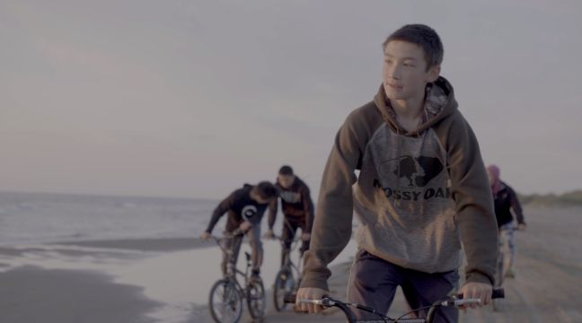 Kenny und andere Jugendliche auf BMX-Rädern am Strand
