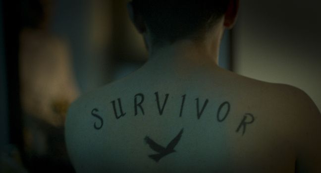 Besnik  Hyseni mit Tattoo 'Survivor'